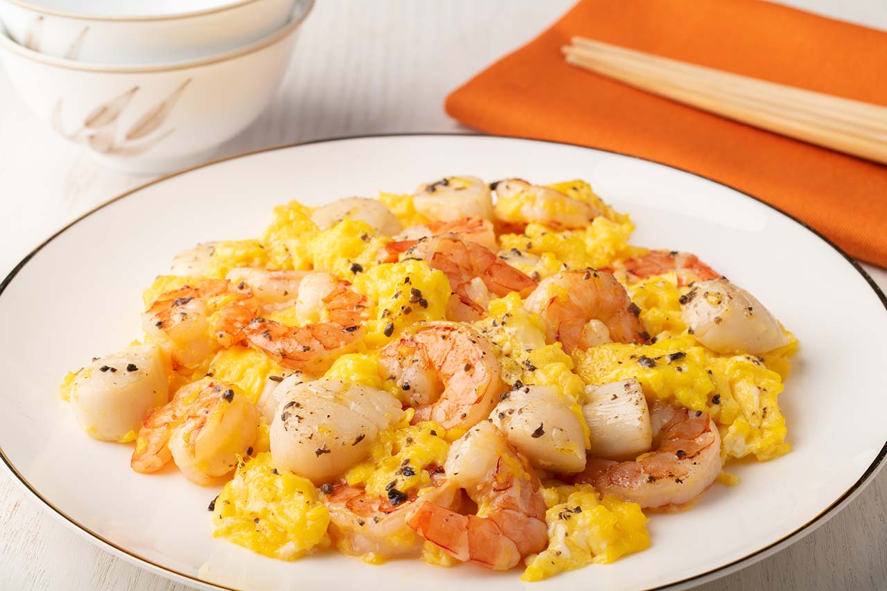 Œufs brouillés aux truffes, pétoncles et crevettes